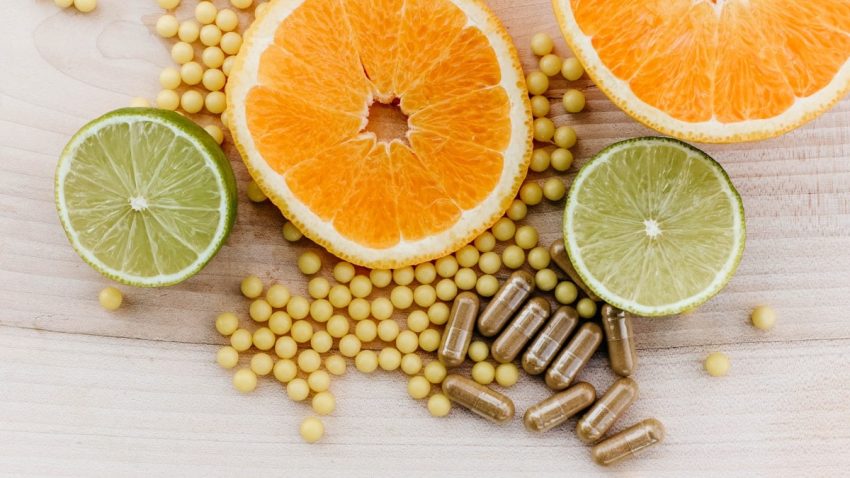 oranges, peas, and limes on a wooden table